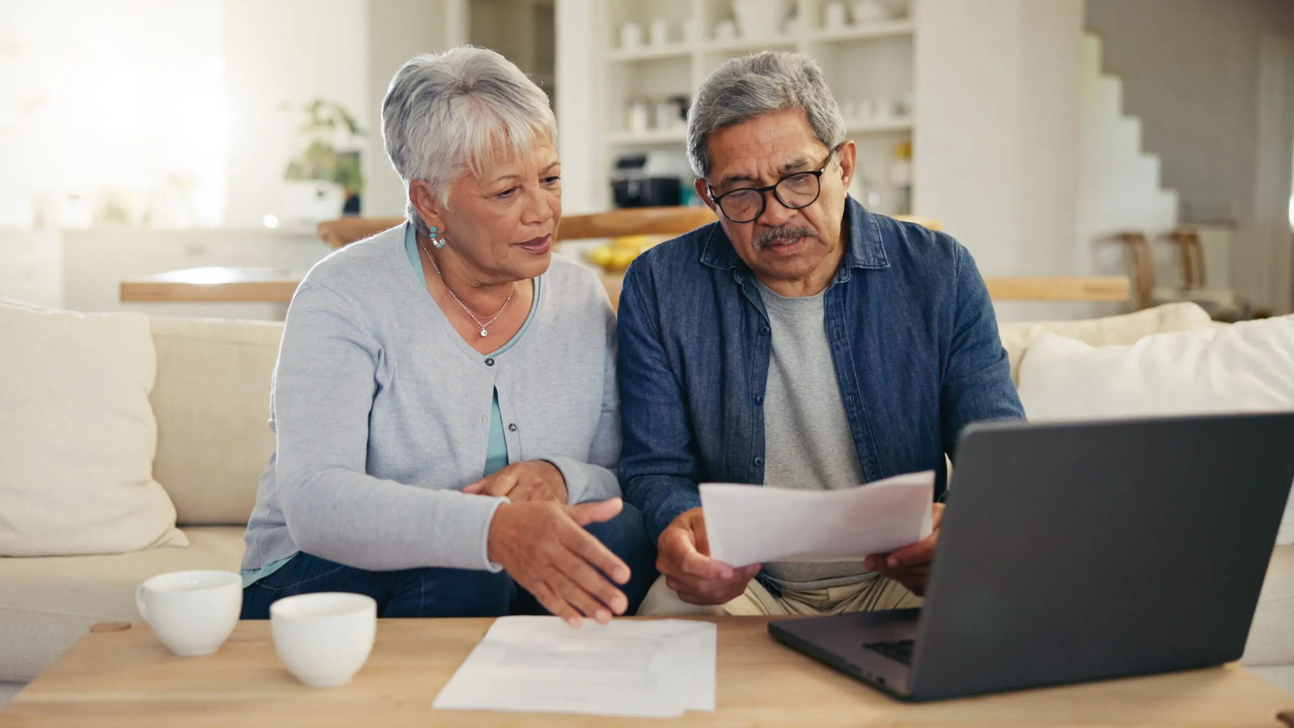 A couple sit in front of a laptop and papers and make an emergency plan during National Preparedness Month