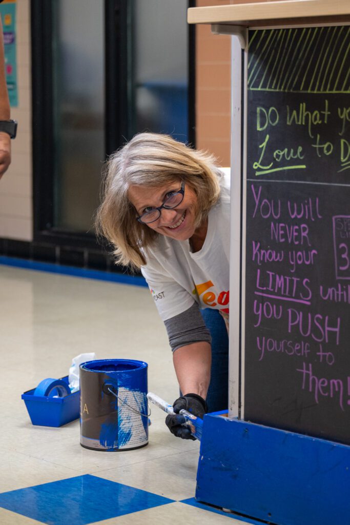 A Comcast TeamUp volunteer paints trim in the Boys & Girls Club of Flint's Averill Club site. 