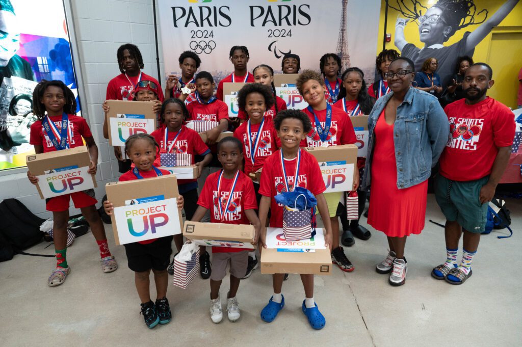 Boys & Girls Club of Southeastern Michigan members pose with medals and laptops, donated by Comcast, after completing Olympic-themed field day activities.