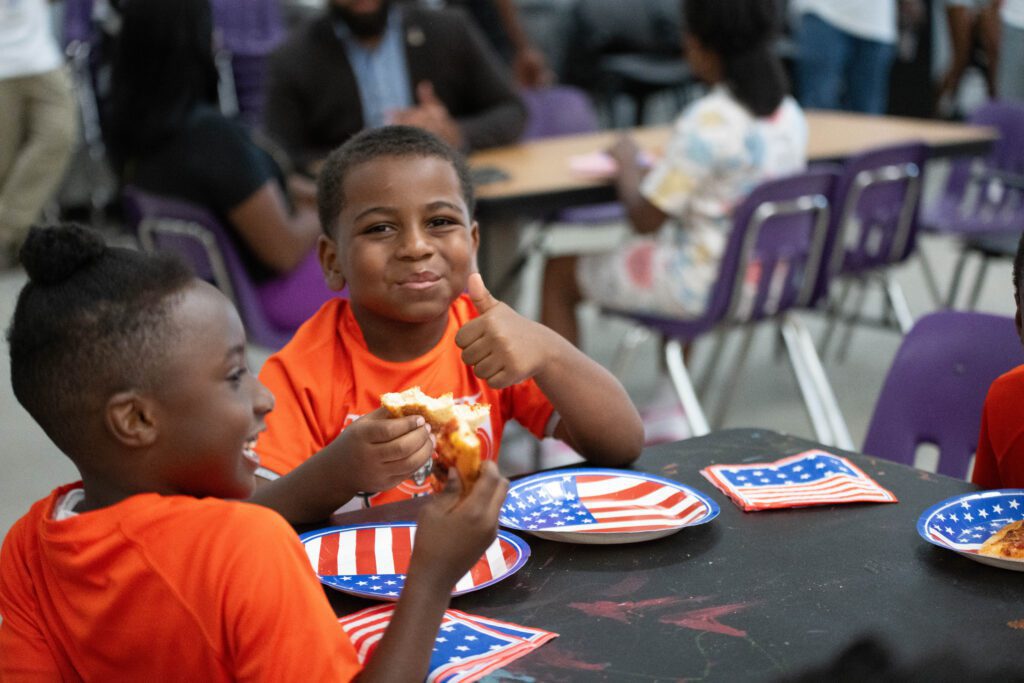 Members of the Boys & Girls Clubs of Southeastern Michigan enjoy pizza donated by the Chaldean Chamber of Commerce and Hungry Howies Detroit.