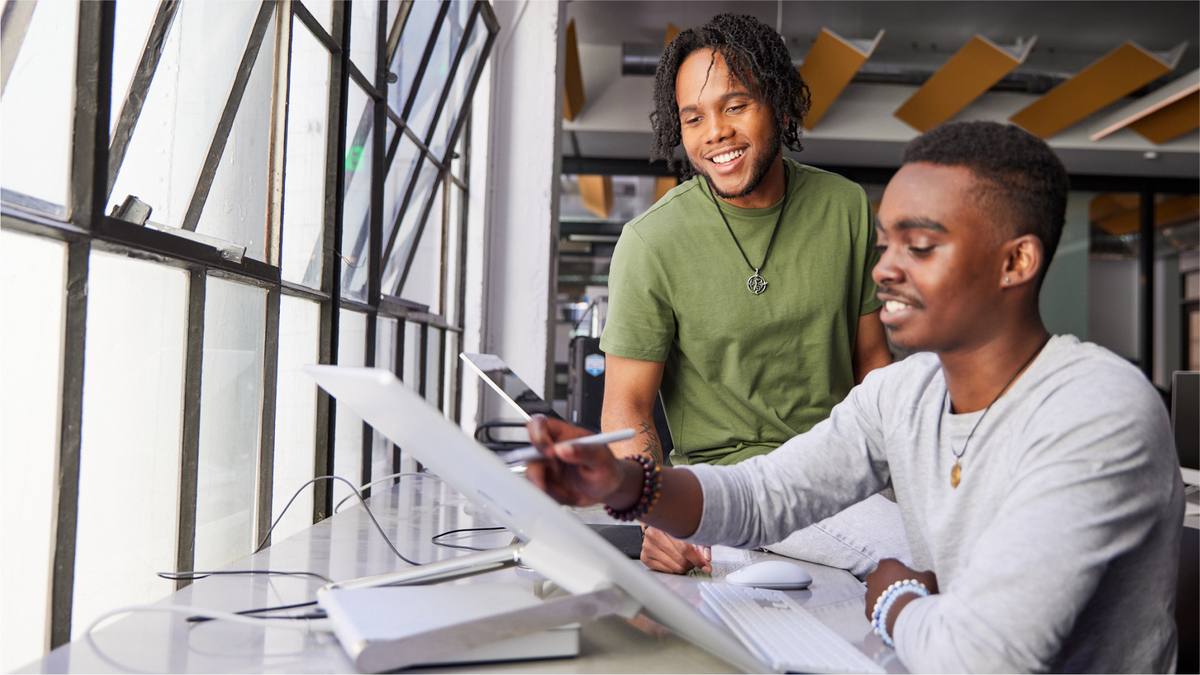Kevin helping a student at a computer